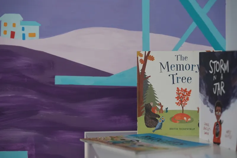Children's bereavement books, including The Memory Tree, on display in the Rainbow Room