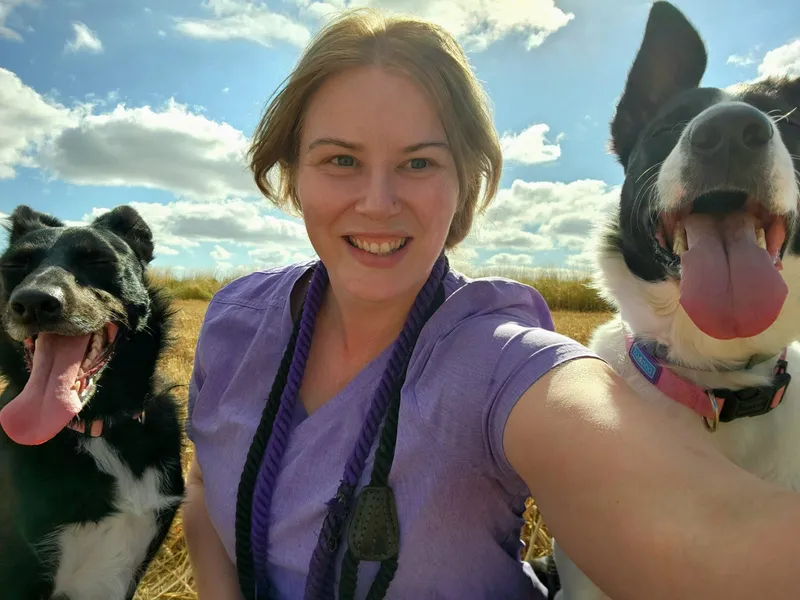 Kirstie, Animal Care Assistant at The Veterinary Wellness Centre, outdoors with a Border Collie